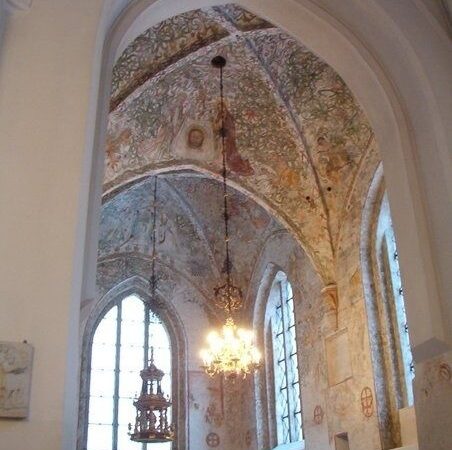 Medeltida kyrkorum i Husaby med målade valv och ljuskrona
